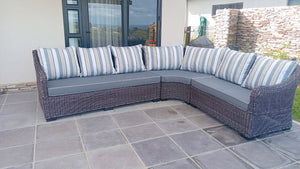 Sectional outdoor sofa with striped cushions on a tiled patio